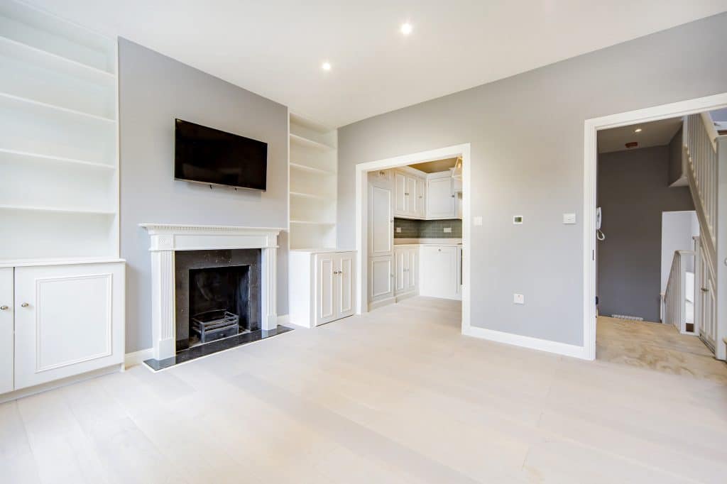 Fulham Modern living room with fireplace, built-in shelving, and an open view to the kitchen