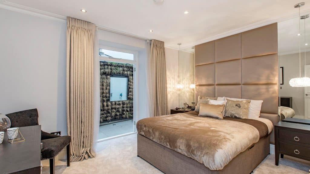 Luxury bedroom with soft furnishings, large bed, and warm lighting