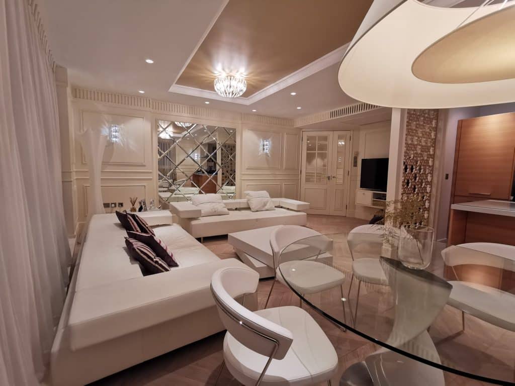 Paddington Luxurious living area with sectional seating, large windows, and warm lighting