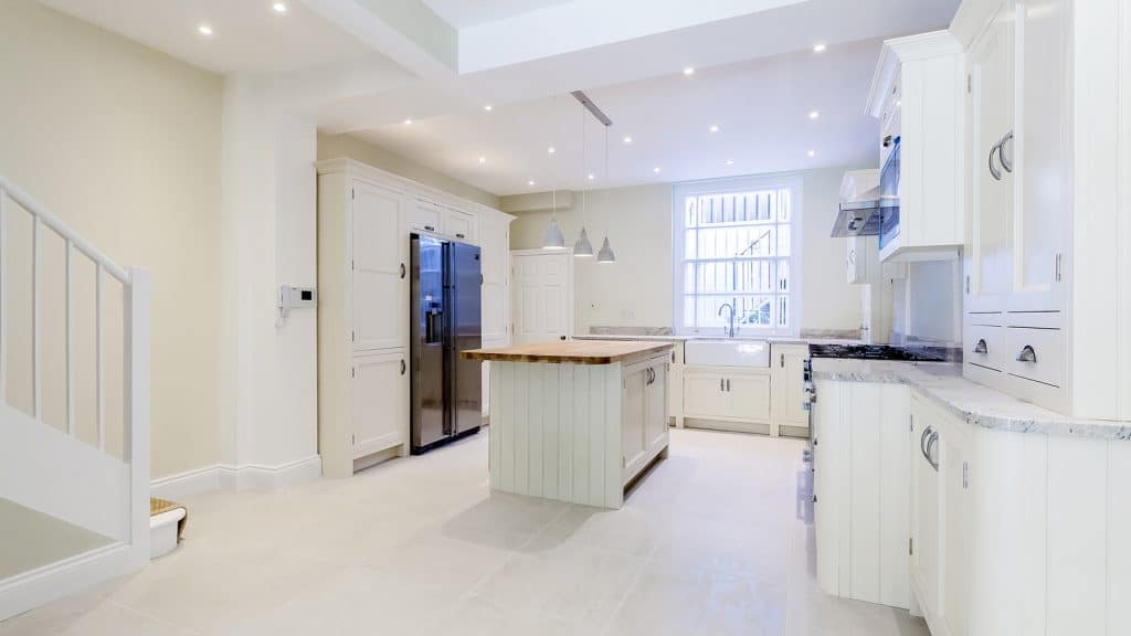 Open-plan kitchen with central island, pendant lights, and a large cooking range