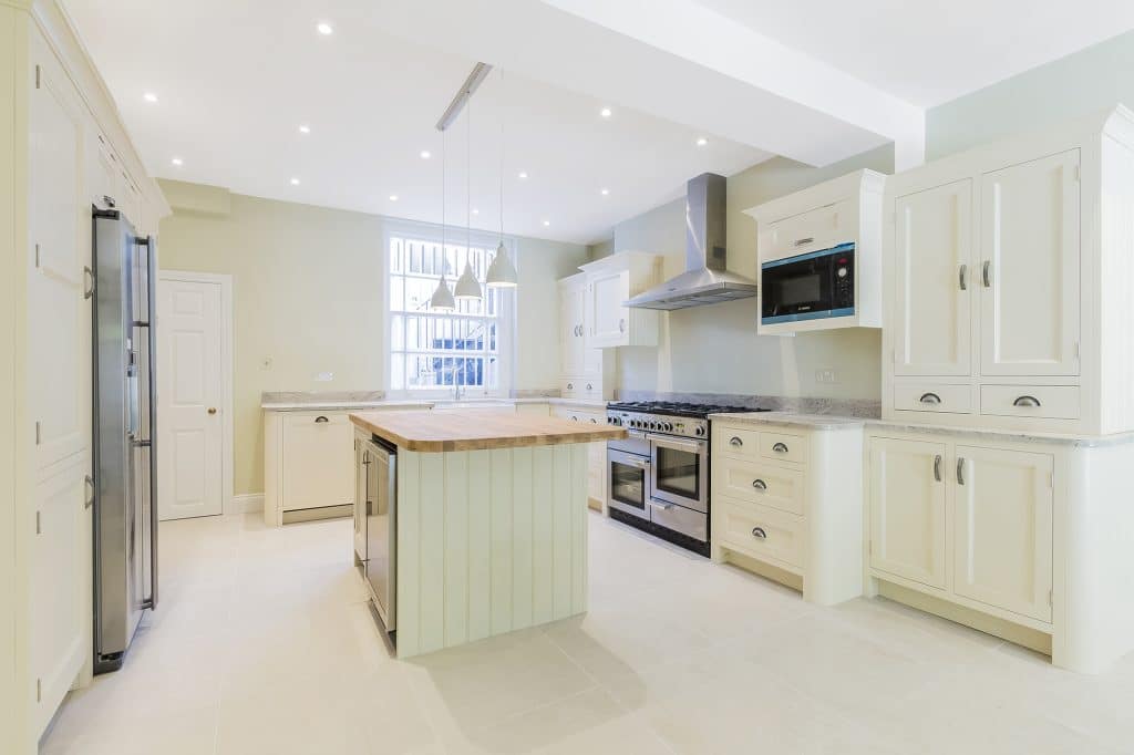 Modern kitchen with cream cabinetry, central island, and pendant lighting